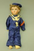 A small bisque headed doll by Armand Marseille in sailors uniform. 28 cm high.