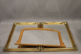Two modern gilt framed mirrors and a pine over mantle mirror. The former each 105 x 75 cm.