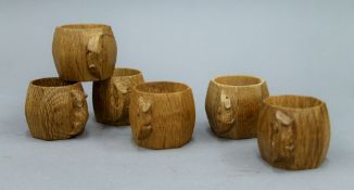 Six Mouseman carved oak napkin rings. Each approximately 5 cm high.