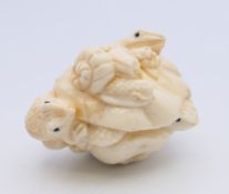 A bone carving of frogs. 5 cm long.