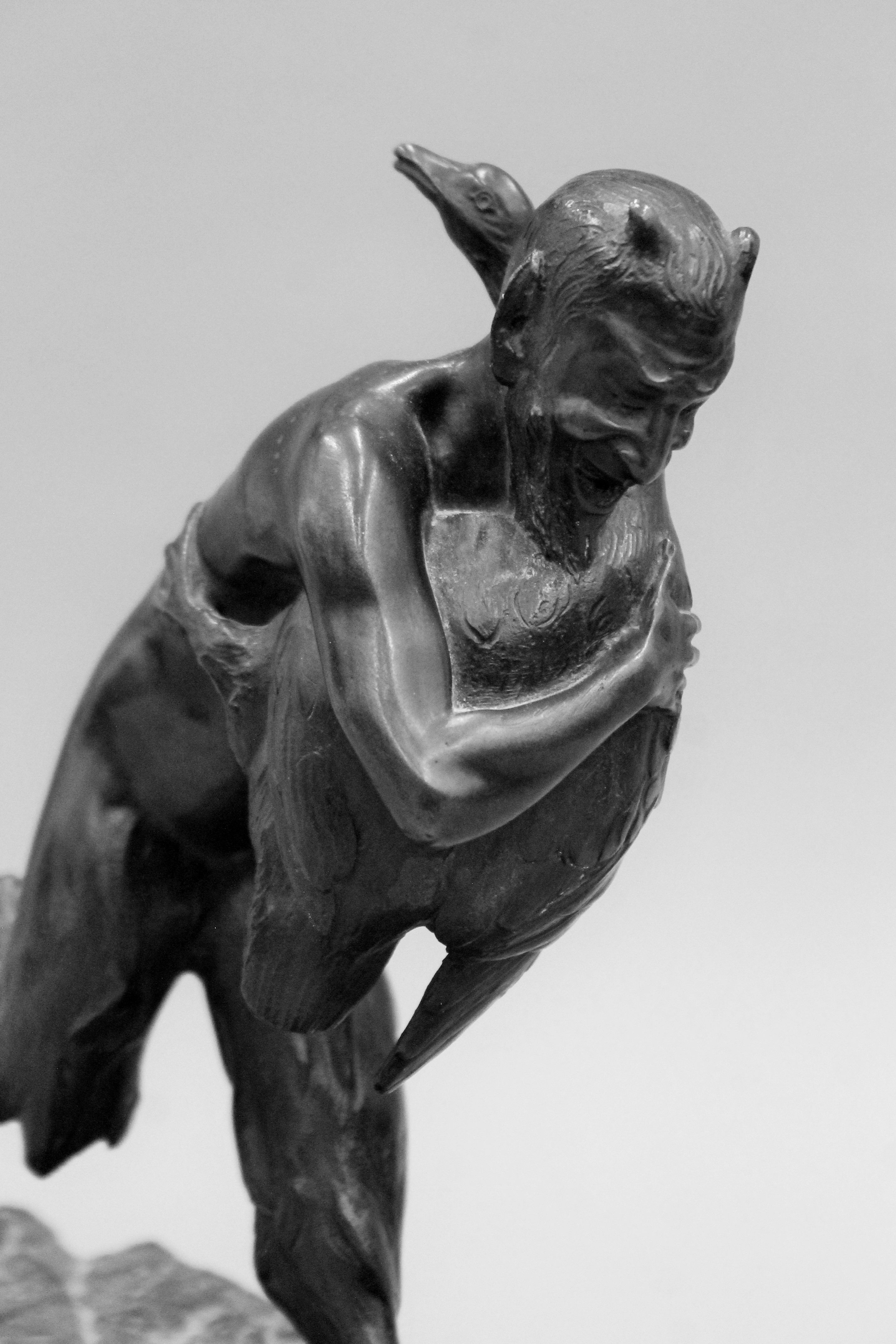 A patinated bronze model a faun and a goose mounted on a carved stone base. 26 cm high. - Image 3 of 4