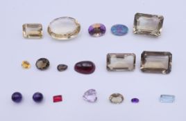 A box of loose gem stones, including opal, quartz, amethyst, etc. The largest 3 cm long.
