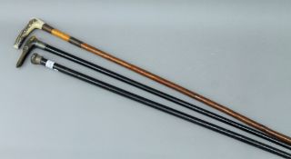 Three walking sticks - one with silver finial,