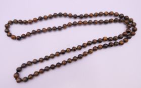 A tigerseye bead necklace. 92 cm long.