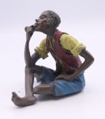 A cold painted bronze of a boy smoking a pipe. 5.5 cm high.