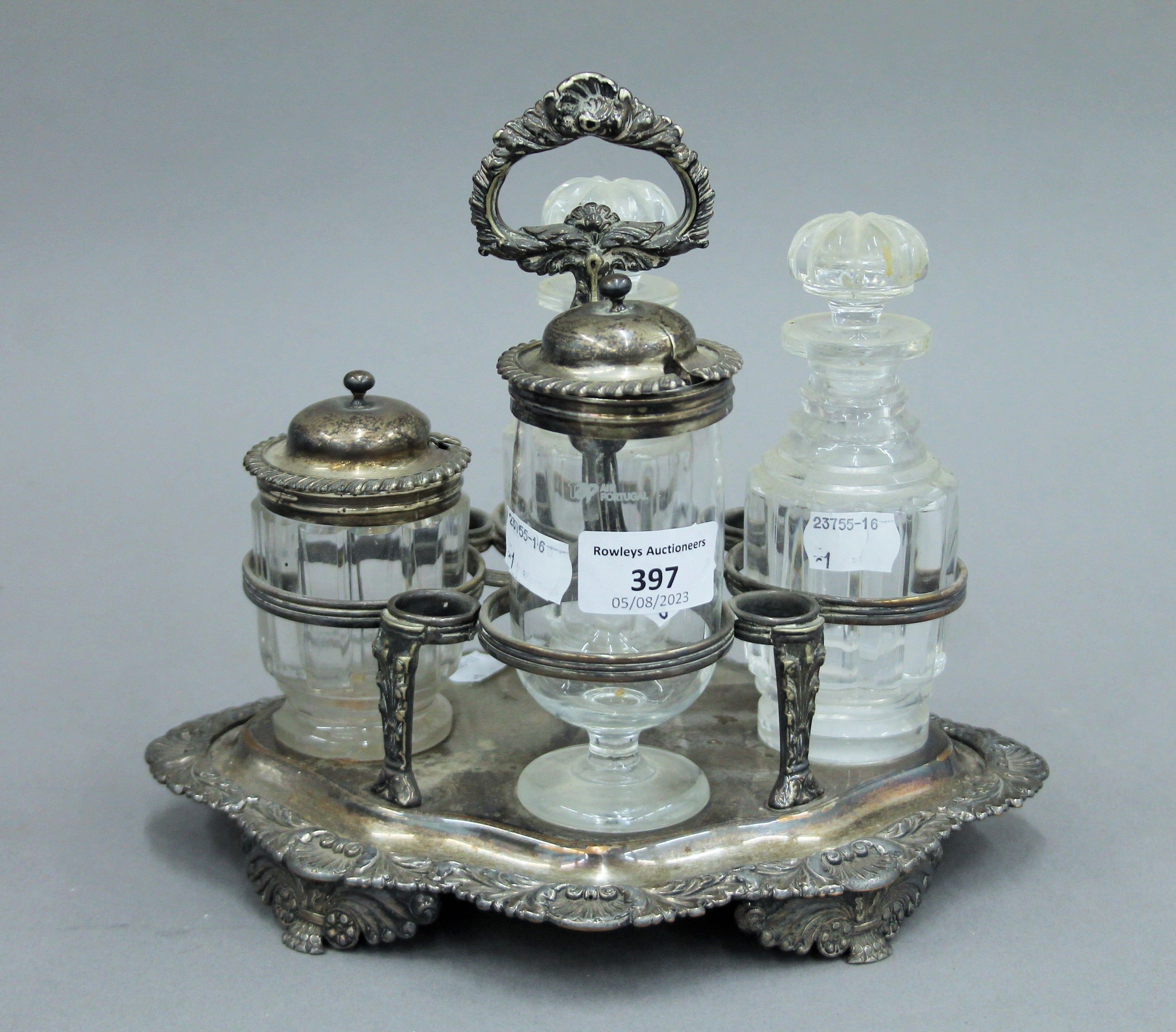 A silver plated cruet stand with associated fittings, two with silver mounts and a small silver lid.
