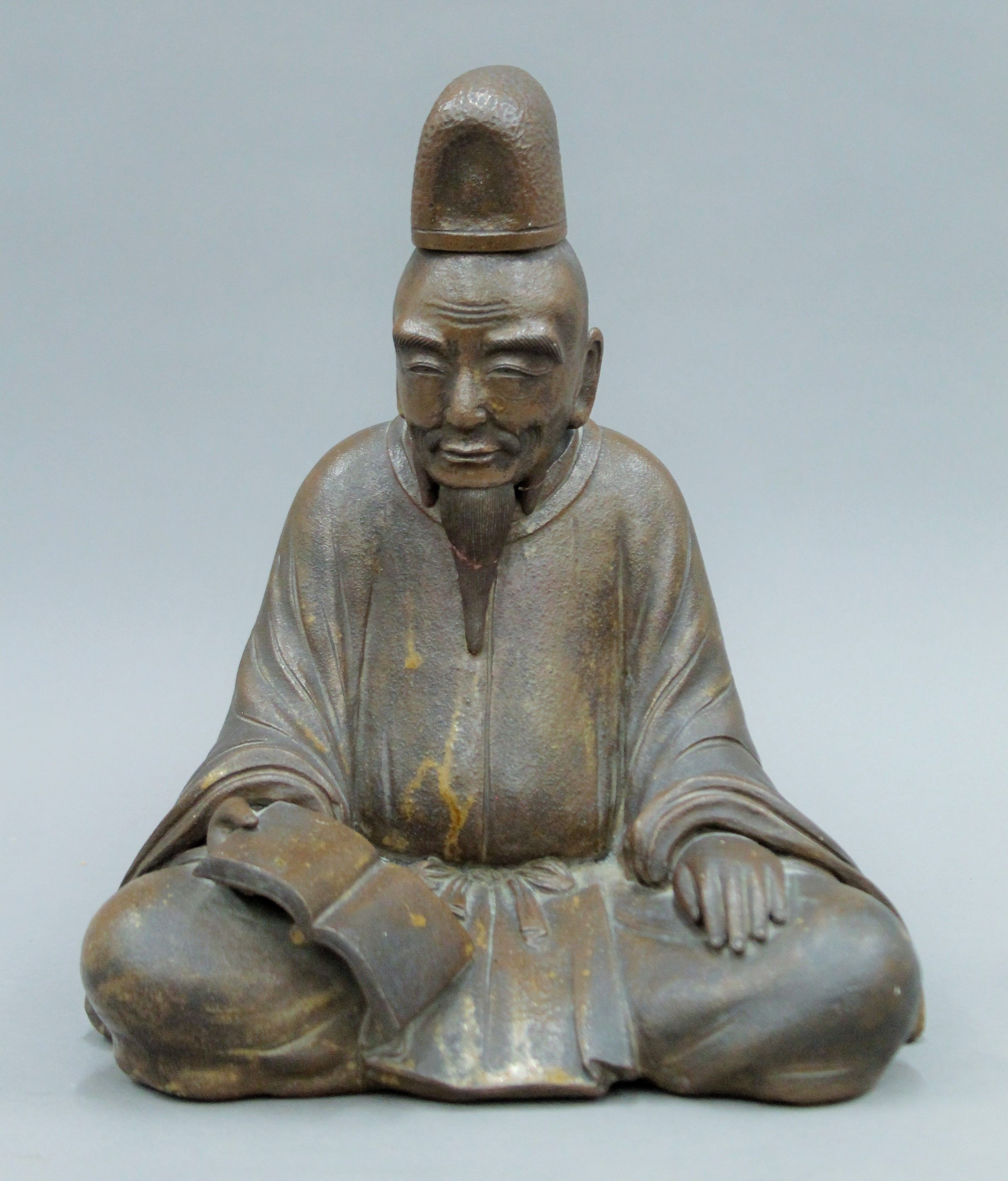 An Oriental pottery figure of a scholar. 30 cm high.