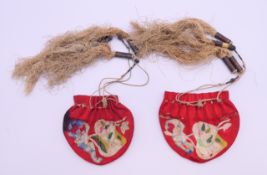 A pair of Chinese embroidered opium pouches. Each approximately 9 cm wide.