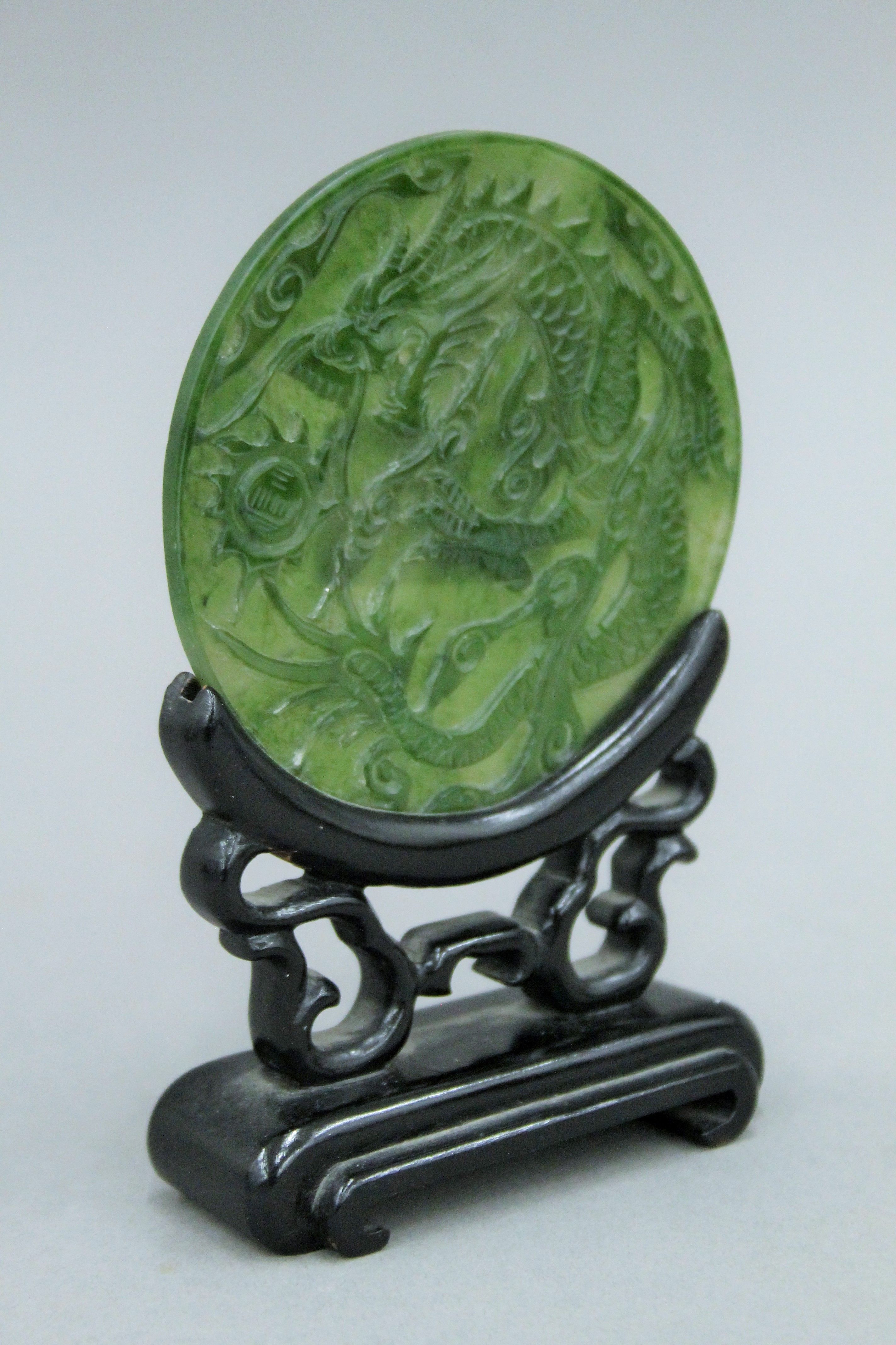 A small Chinese carved spinach jade disc on carved wooden stand. 13.5 cm high. - Image 3 of 4