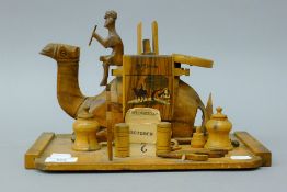A wooden camel form desk stand. 30 cm wide.