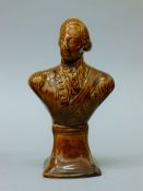 A 19th century treacle glazed pottery bust of Nelson. 20 cm high.