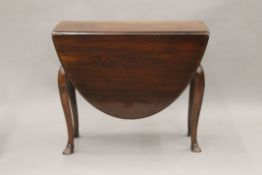 A 19th century walnut single drawer oval drop leaf table with cabriole legs and hoof feet.