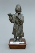An 18th century Chinese bronze model of a flute player mounted on a wooden plinth base. 16 cm high.