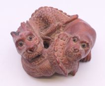 A netsuke formed as a dog of fo and dragon. 6 cm wide.