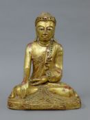 A gilt wood model of Buddha. 32.5 cm high.