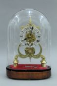 A brass skeleton clock under glass dome. 40 cm high overall.