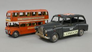 A tin plate model of a London taxi and a double decker bus. The former 41 cm long.