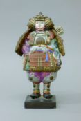 A pottery model of a samurai mounted on a wooden base. 21 cm high.