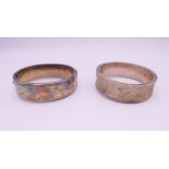 Two silver bangle formed bracelets. The largest 6.5 cm wide. 58.7 grammes.