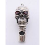 A silver skull form whistle. 4 cm high.