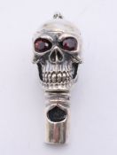 A silver skull form whistle. 4 cm high.