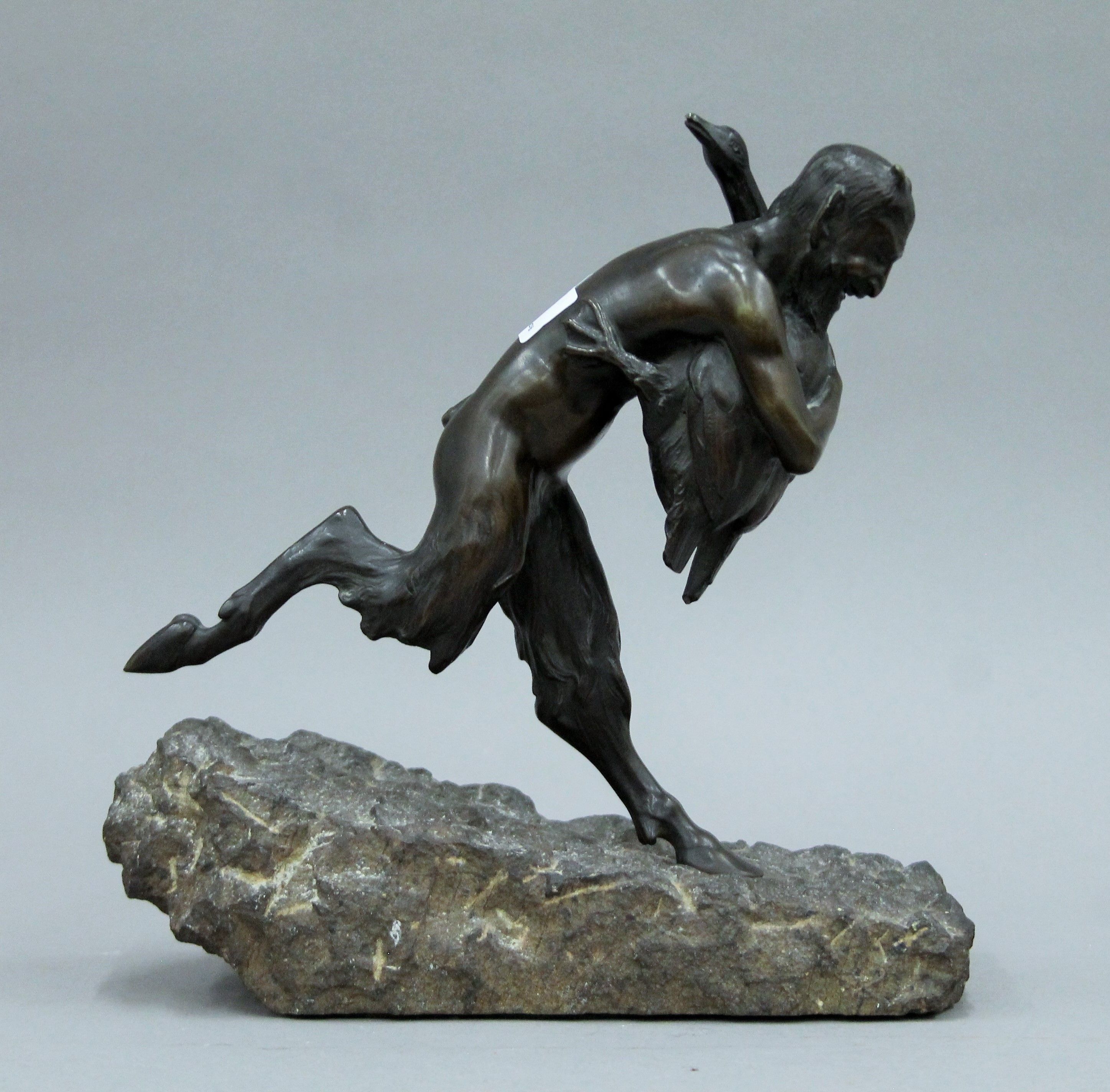 A patinated bronze model a faun and a goose mounted on a carved stone base. 26 cm high. - Image 2 of 4