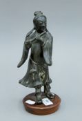 An 18th century Chinese bronze model of a flute player mounted on a wooden plinth base. 23.