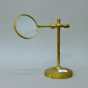 A brass desk magnifier on stand. 40 cm high overall.