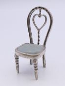 A miniature silver chair. 4.5 cm high.