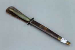 A Fairbairn-Sykes fighting knife in leather scabbard. 31.5 cm long.