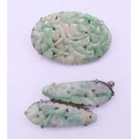 Two silver and jade brooches. The largest 4 cm wide.