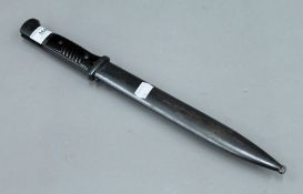 A bayonet in scabbard. 40.5 cm long.