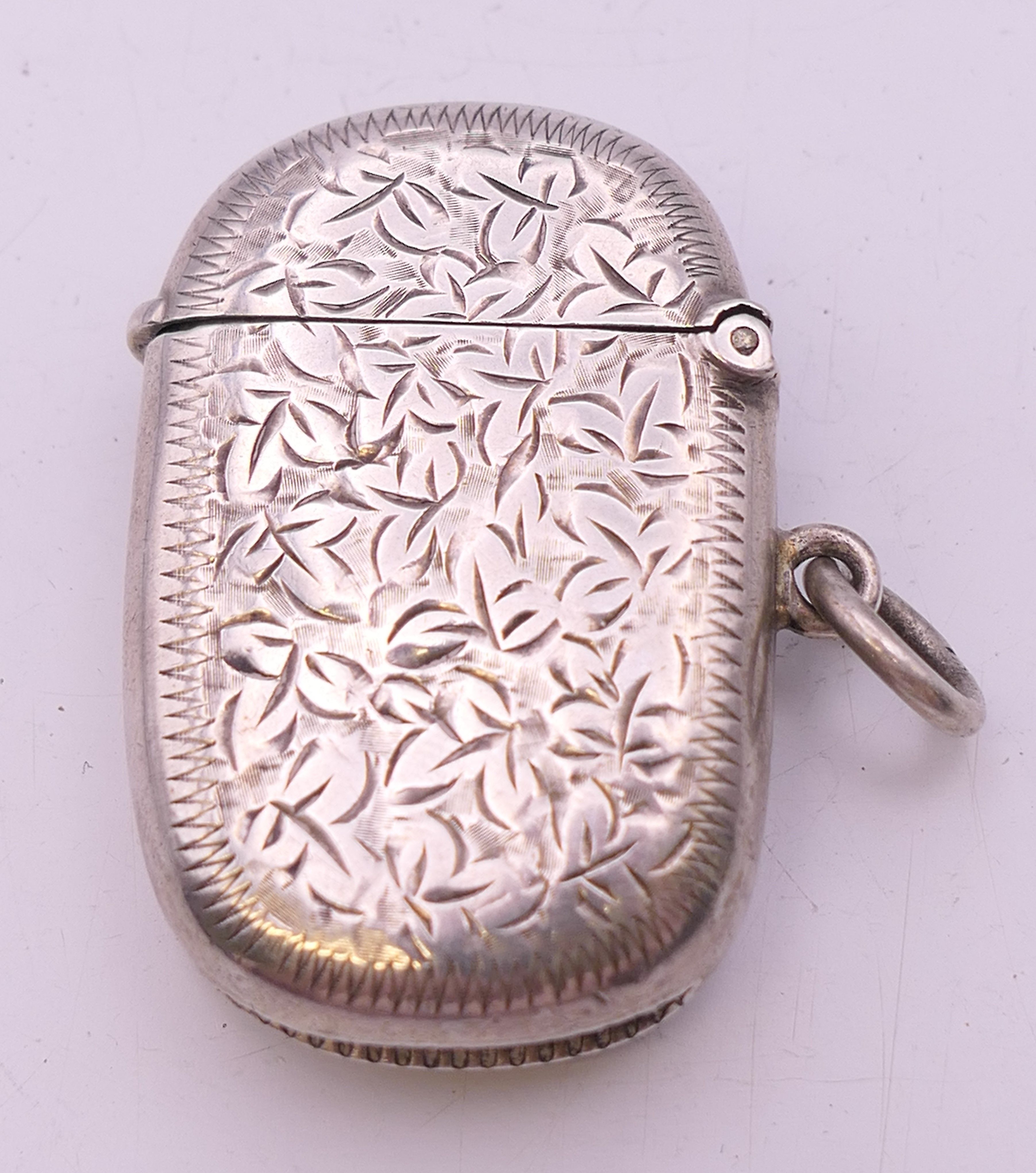 A Victorian silver vesta with leaf chased pattern, Birmingham 1898. 4 cm wide. 14.8 grammes. - Image 2 of 5