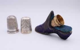 Two silver thimbles and an unmarked 9 ct gold thimble housed in a miniature shoe. The shoe 5.