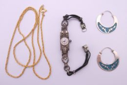 A silver cocktail watch, a pair of silver and turquoise earrings, and a chain. The former 1 cm wide.