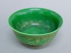 A Chinese green porcelain bowl decorated with dragons. 15.5 cm diameter.