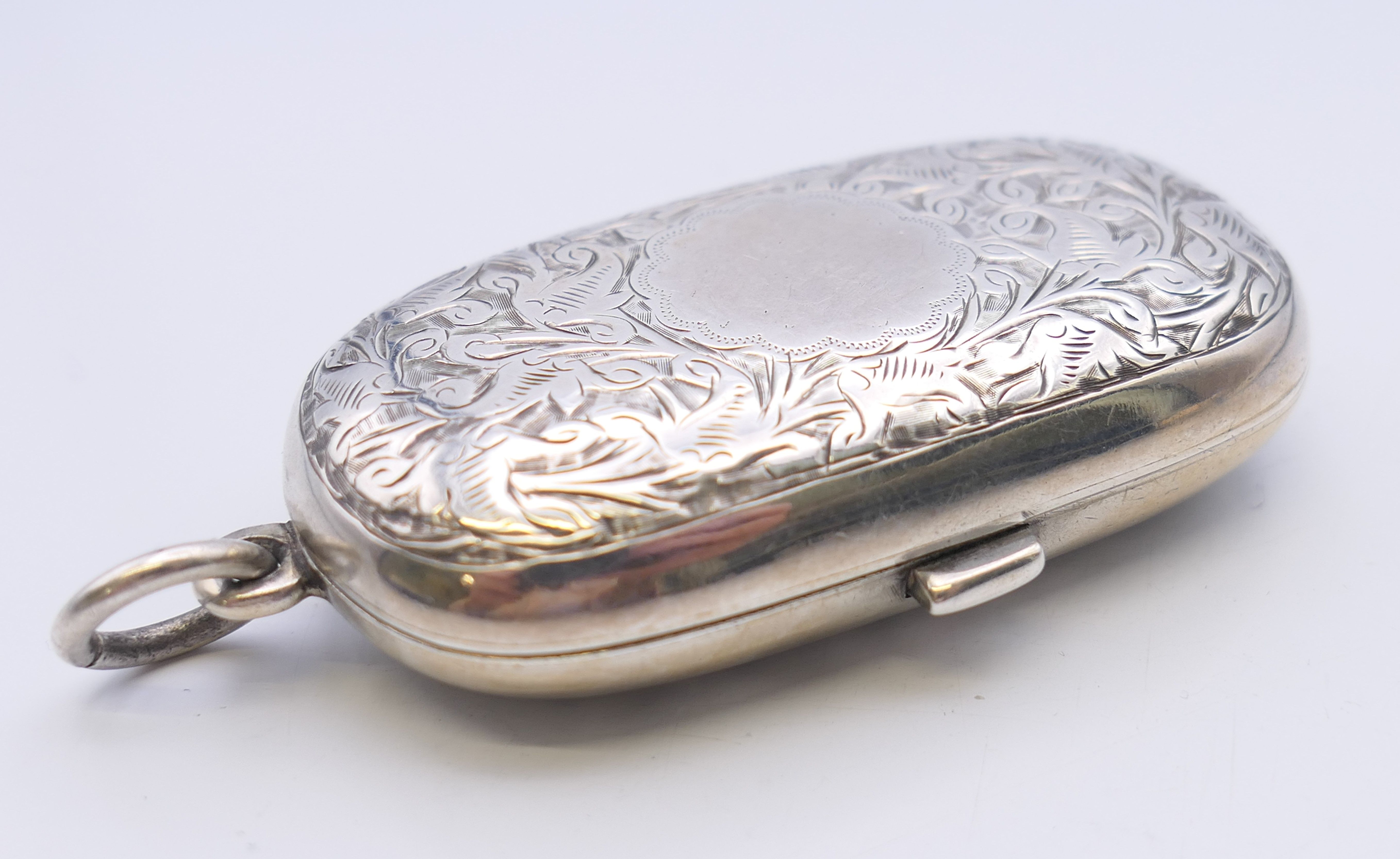 A Victorian silver sovereign case with leaf chased pattern, Birmingham 1886. 6 cm wide. 40 grammes. - Image 3 of 7