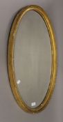 A gilt framed oval bevelled mirror. 51.5 x 82 cm.