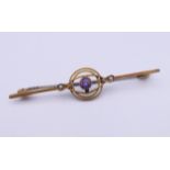 A 9 ct gold amethyst and seed pearl set bar brooch. 5 cm long. 1.8 grammes total weight.