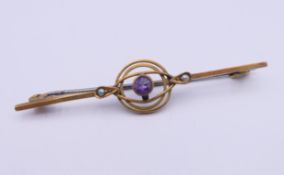 A 9 ct gold amethyst and seed pearl set bar brooch. 5 cm long. 1.8 grammes total weight.