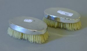A pair of silver backed hair brushes. Each 12.5 cm long.