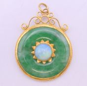 A Chinese unmarked high carat gold mounted jade and opal pendant. 3.75 cm diameter. 8.