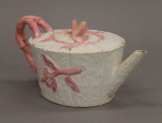A 19th century porcelain teapot decorated with pink flowers. 11 cm high.