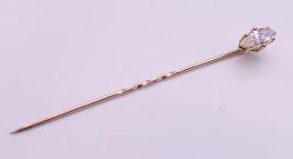 A 9 ct gold stick pin set with cubic zirconia. 1 gram total weight.