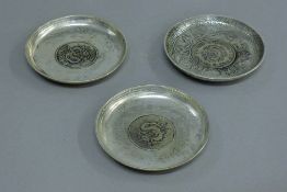 Three Chinese white metal dishes. 9 cm diameter.