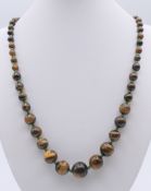 A tigerseye bead necklace, 64 cm long.