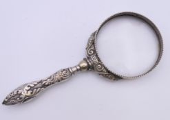 A magnifying glass with ornate silver handle, hallmarked Birmingham 1900. 15.5 cm long.