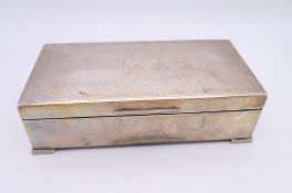 A silver cigarette box, hallmarked for London 1959, maker's mark of JR over C&C. 18 cm wide.