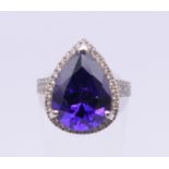 An 18 ct white gold diamond and purple stone set ring. Ring size H/I. 5.1 grammes total weight.