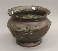 A Japanese bronze jardiniere decorated with dragons. 23 cm high.